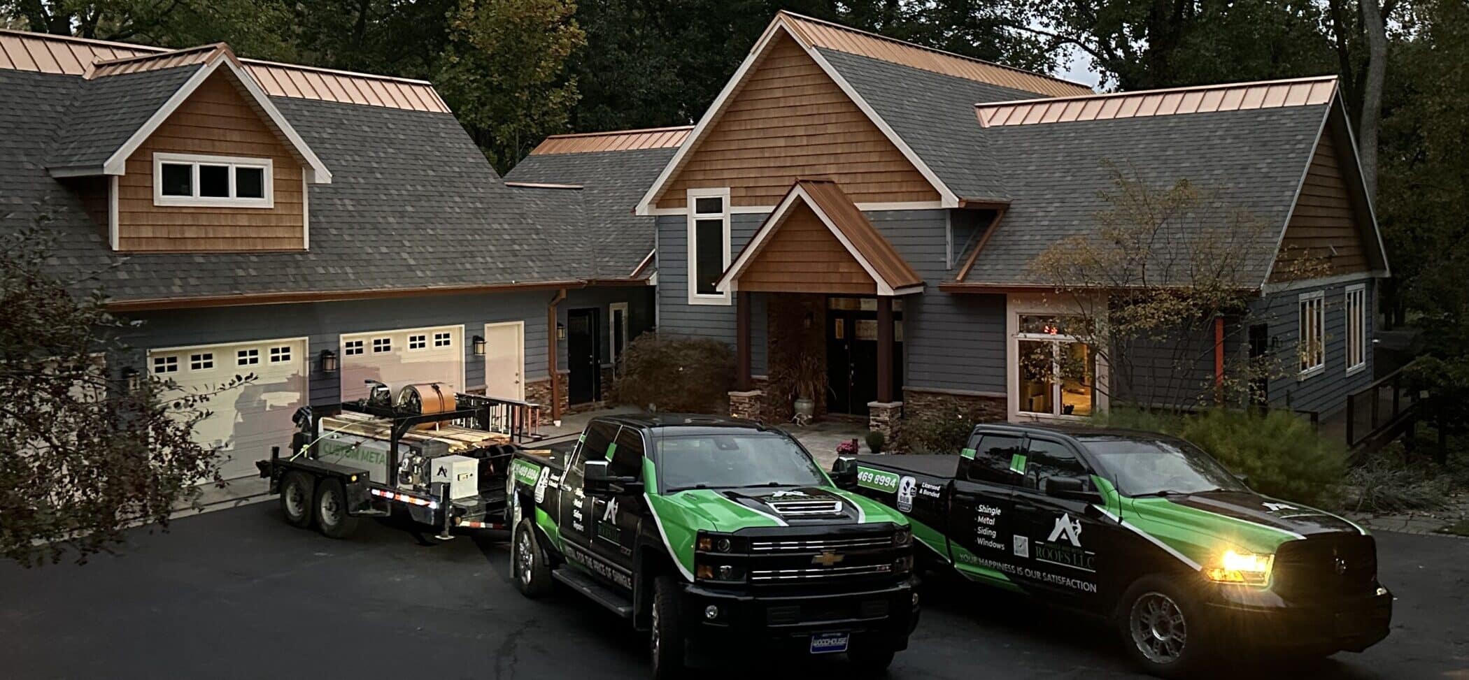 SMR Home Pros company trucks in front of a recently installed shingle roof with copper ridge cap featuring installation by SMR Home Pros