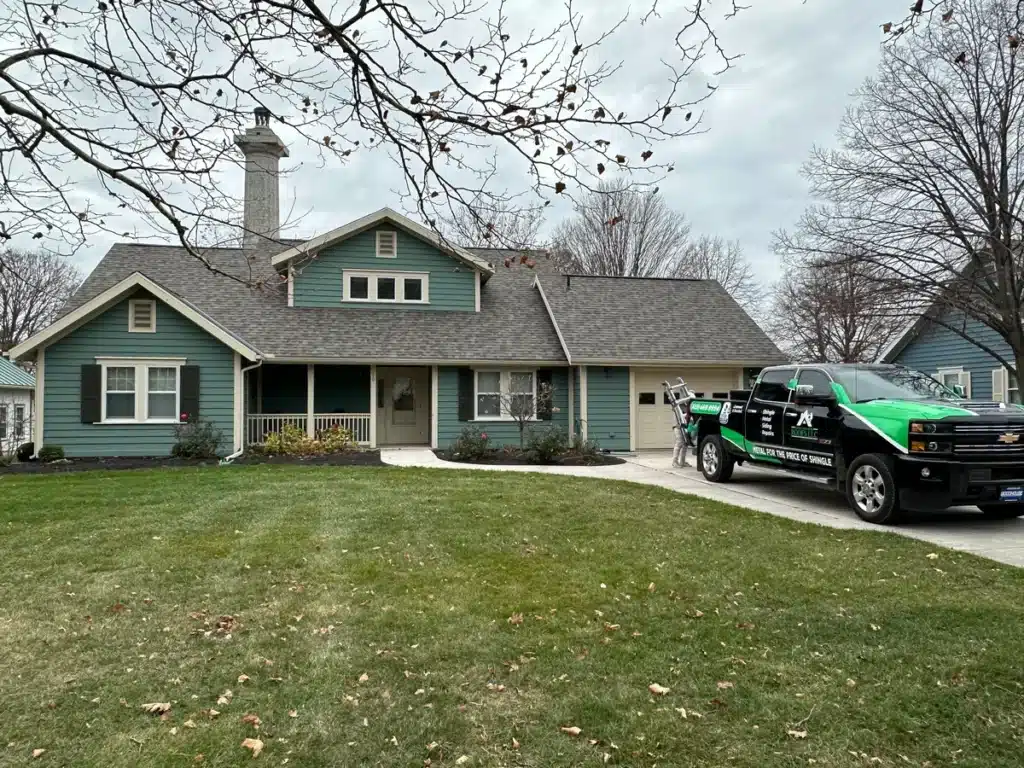 SMR Home Pros truck parked outside a home after completing a shingle roofing replacement.