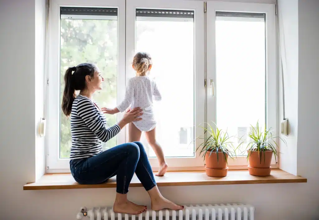 young mom and child look out new fremont window replacements