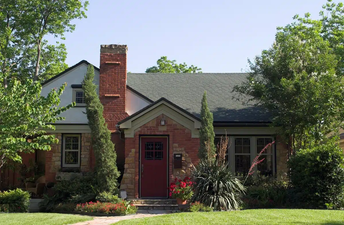 green shingle roof on cottage house with a front yard