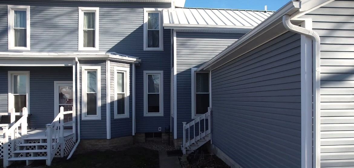 Custom windows paired with blue Polaris vinyl siding installed by SMR Home Pros