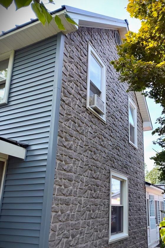 Tandostone vinyl siding impression work on the side of the home paired with Polaris Dutch lap vinyl siding on the front of the home.