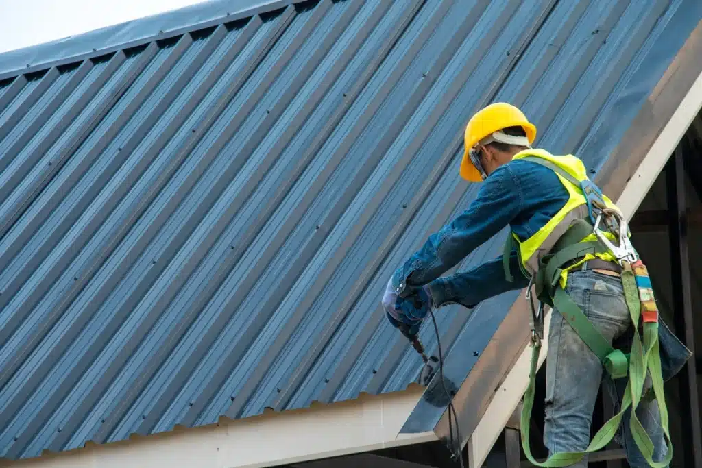 metal screws - roof tech using power tools to apply screws to metal roof