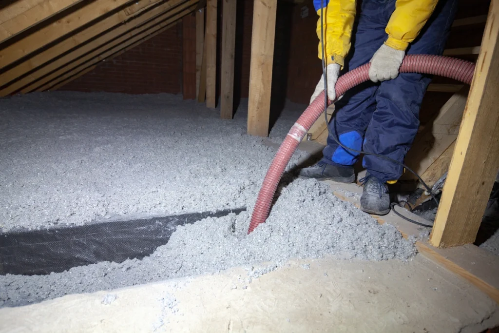 attic insulation removal-technician using hose for insulation