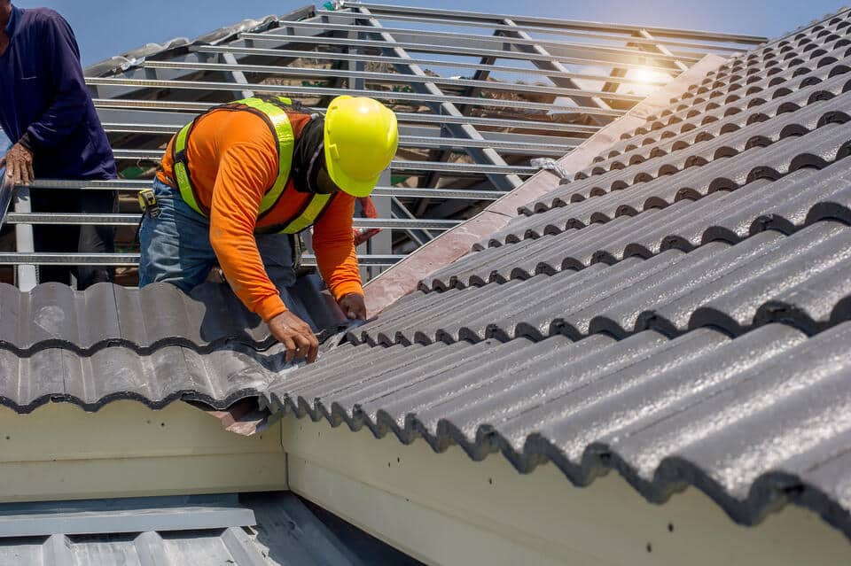 affordable roofing-gray tile roofing being installed on a home