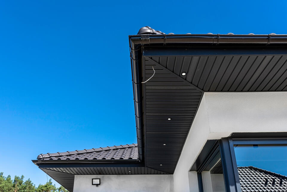 roof eaves-black roofing and eaves on a white house