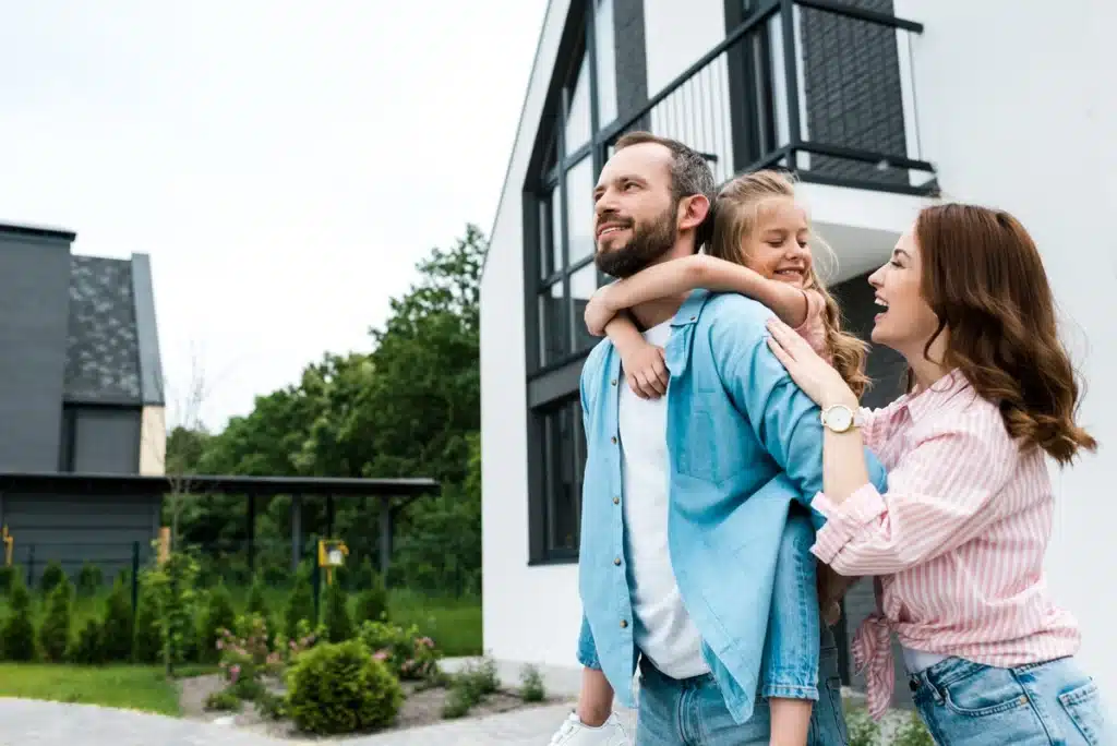 family of three outside of their house- metal roofing mansfield