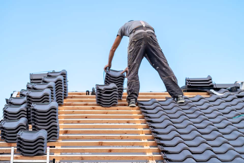 roof warranty-piles of roofing materials on a roof during installation