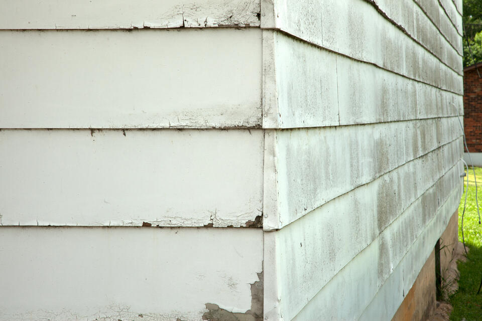 siding repair-close up view of dirty and damaged siding materials on a house