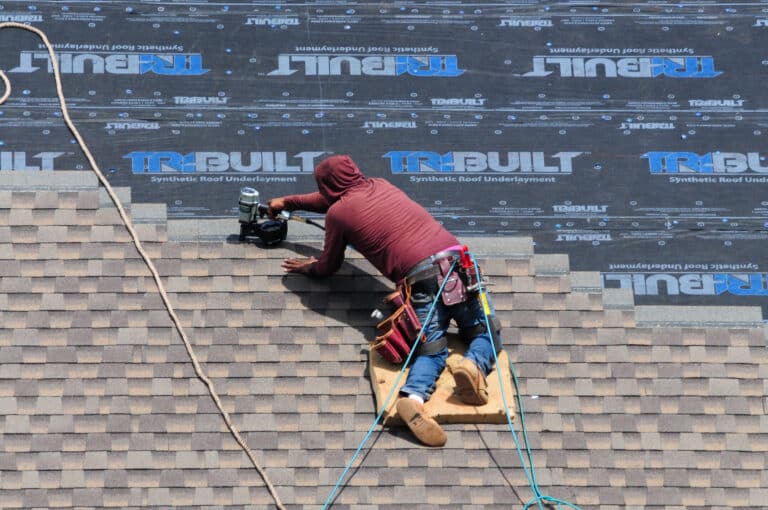 synthetic underlayment-roofer installing new shingles over synthetic roof underlayment