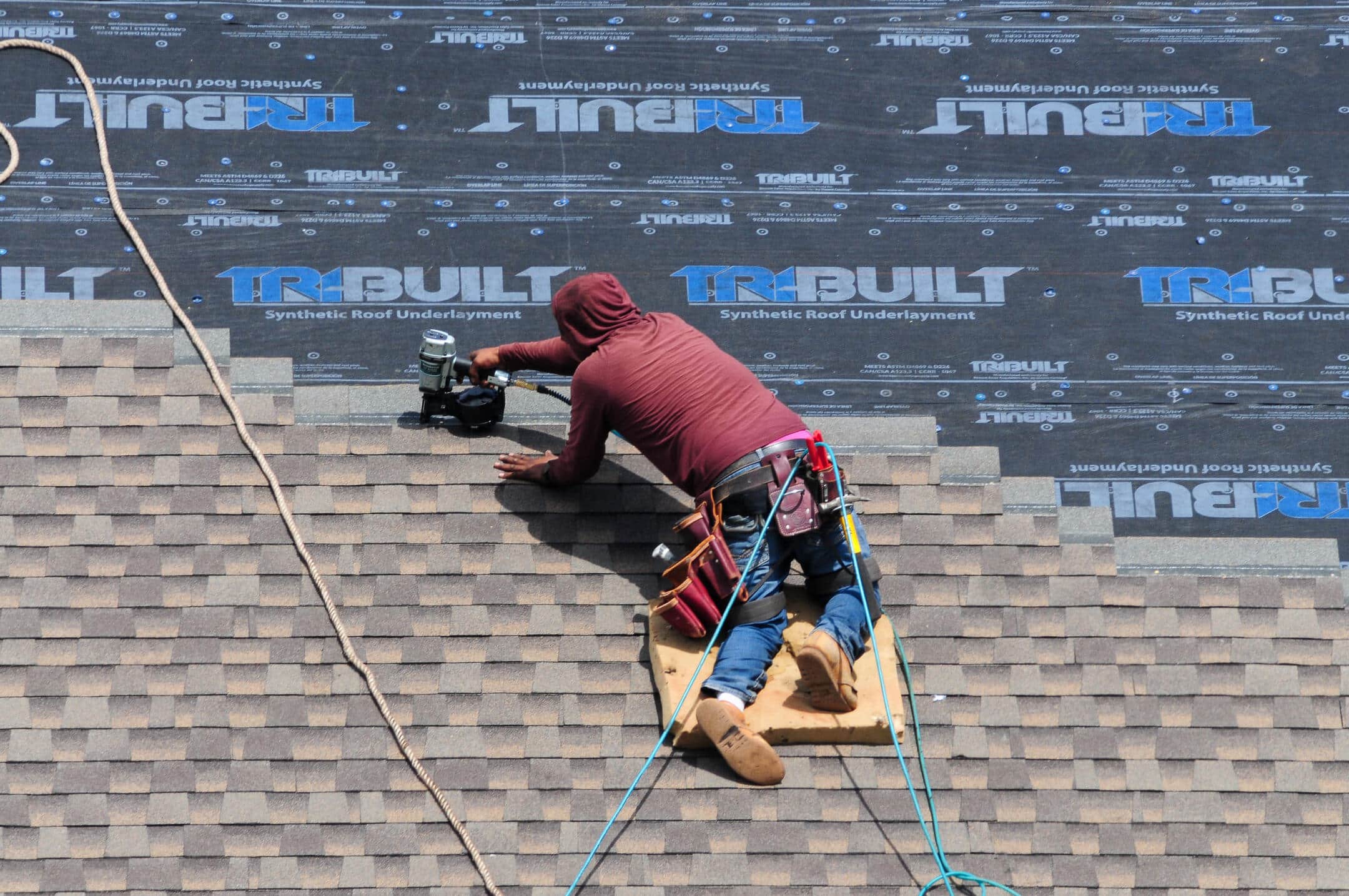 synthetic underlayment-roofer installing new shingles over synthetic roof underlayment