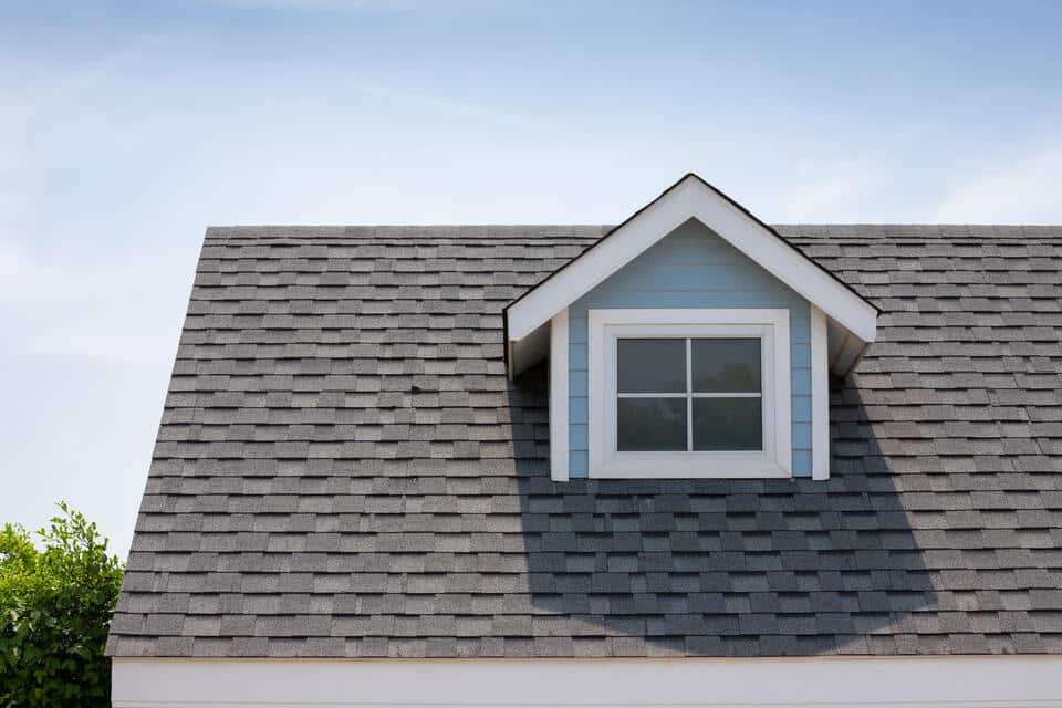 ridge cap shingles-blue sided house with gray roof shingles