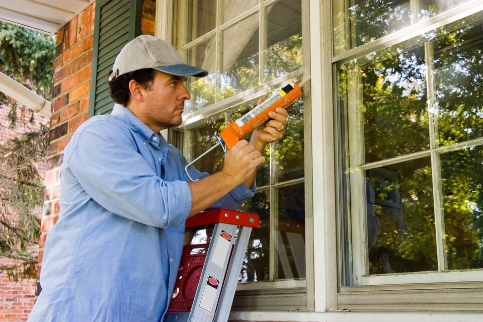 window leaking from top-man repairing caulking around window